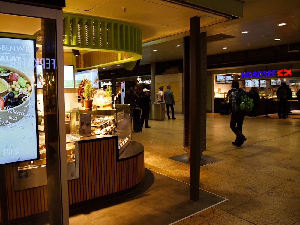 Die Ladenzeile im Kölner Hauptbahnhof bei Dunkelheit.