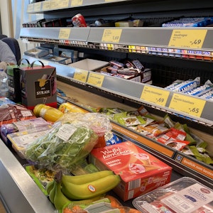 Lebensmittel liegen auf einem Kassenband an einer Supermarktkasse.