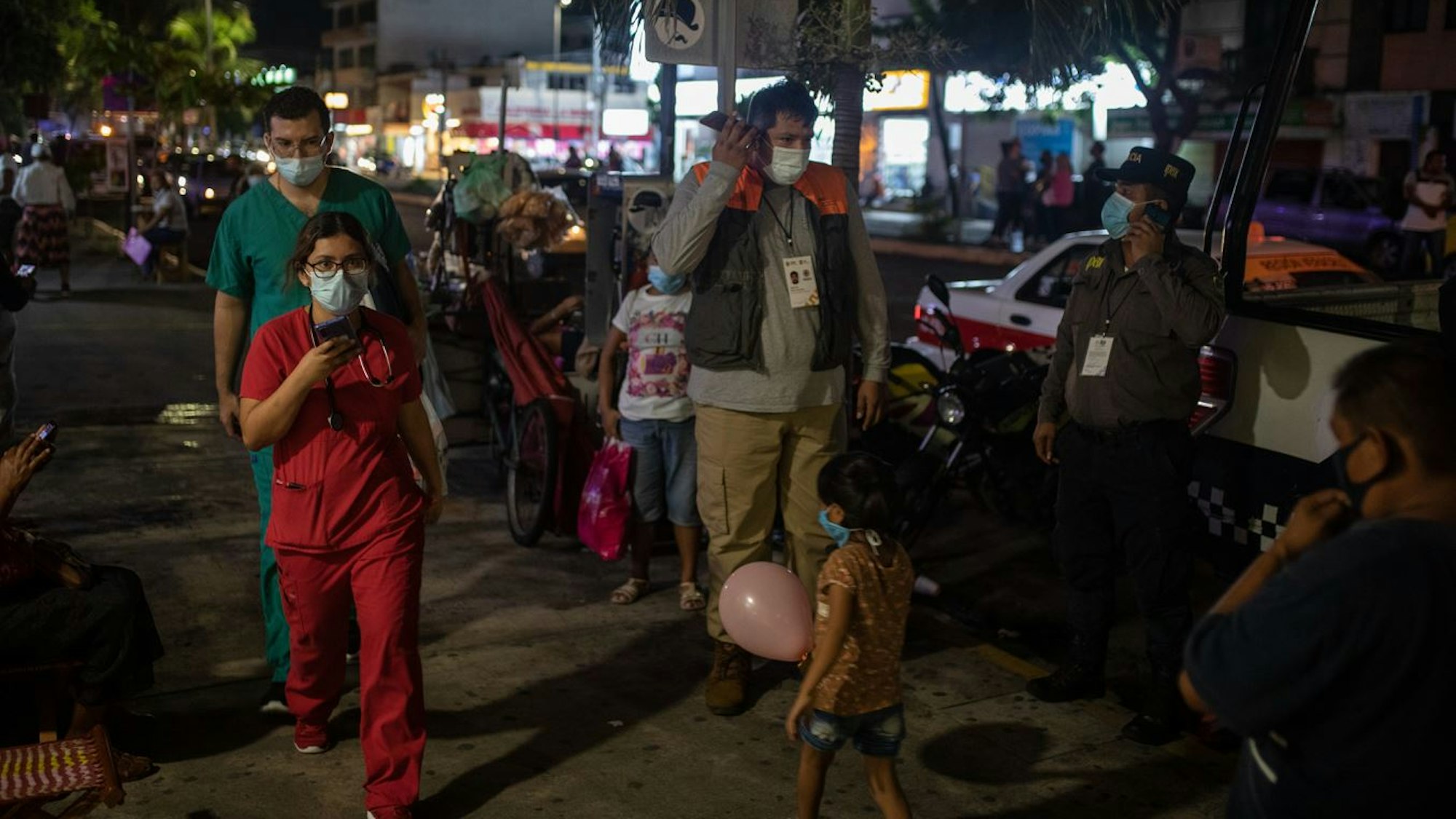 Mitarbeiter des Gesundheitswesens überprüfen ihre Mobiltelefone, während sie nach einem starken Erdbeben vor dem Veracruz General Hospital stehen. 