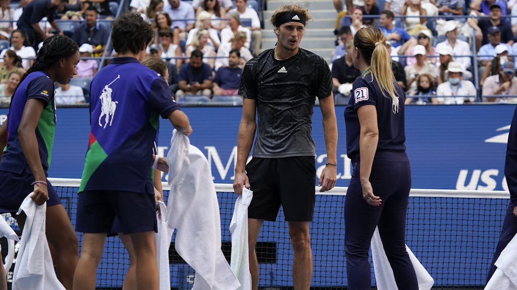 Alexander Zverev, of Germany, talks with court attendants as they dry liquid off the court during the quarterfinals of the US Open tennis championships against Lloyd Harris, of South Africa, Wednesday, Sept. 8, 2021, in New York. (AP Photo/Elise Amendola)