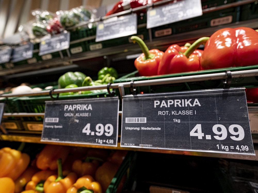 Ein Preisschild von Paprikas hängen an der Obsttheke in einem Supermarkt.