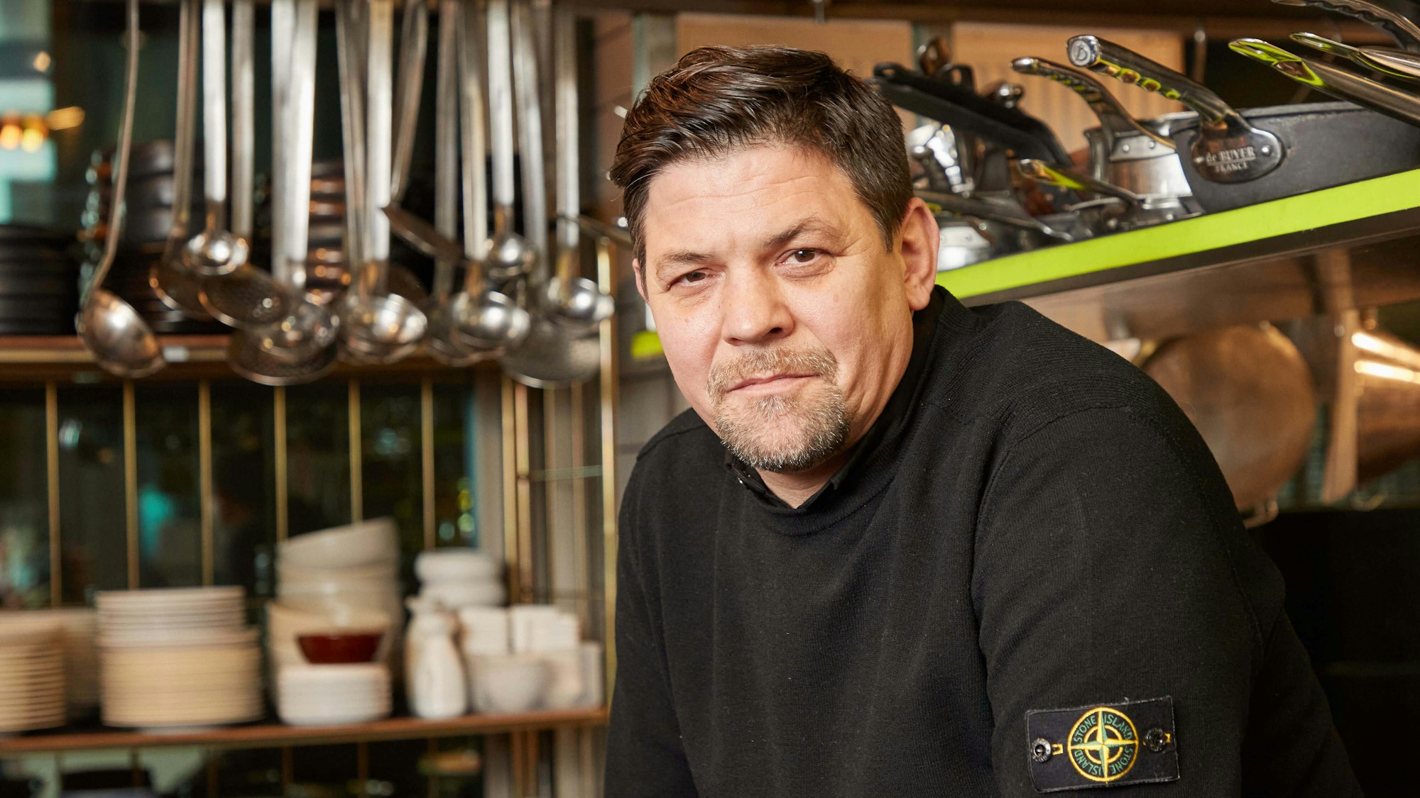 Fernsehkoch Tim Mälzer sitzt in der Küche seines Restaurants „Die Gute Botschaft“.