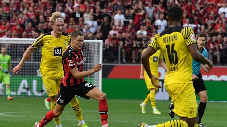 Dortmunds Julian Brandt verfolgt Leverkusens Florian Wirtz.