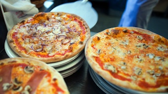 Wer Hunger auf Pizza hat, sollte in NRW bestellen. Das Online-Portal Speisekartenweb.de hat die Preise analysiert. Unser Foto zeigt, wie eine Pizza auf einen Teller geschoben wird.