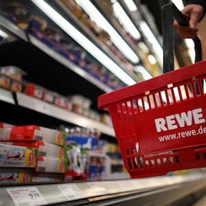 Bei Rewe wird Apfelmark der Firma ODW Lebensmittel GmbH zurückgerufen. Unser Symbolfoto zeigt einen Kunden mit Einkaufskorb vor einem Regal bei Rewe.