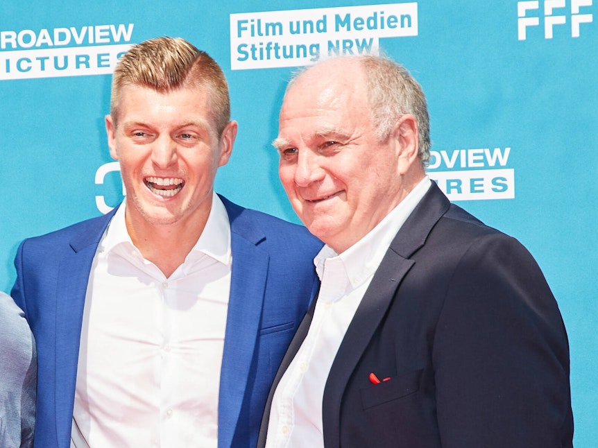 Toni Kroos lacht, an seiner Seite steht Uli Hoeneß.