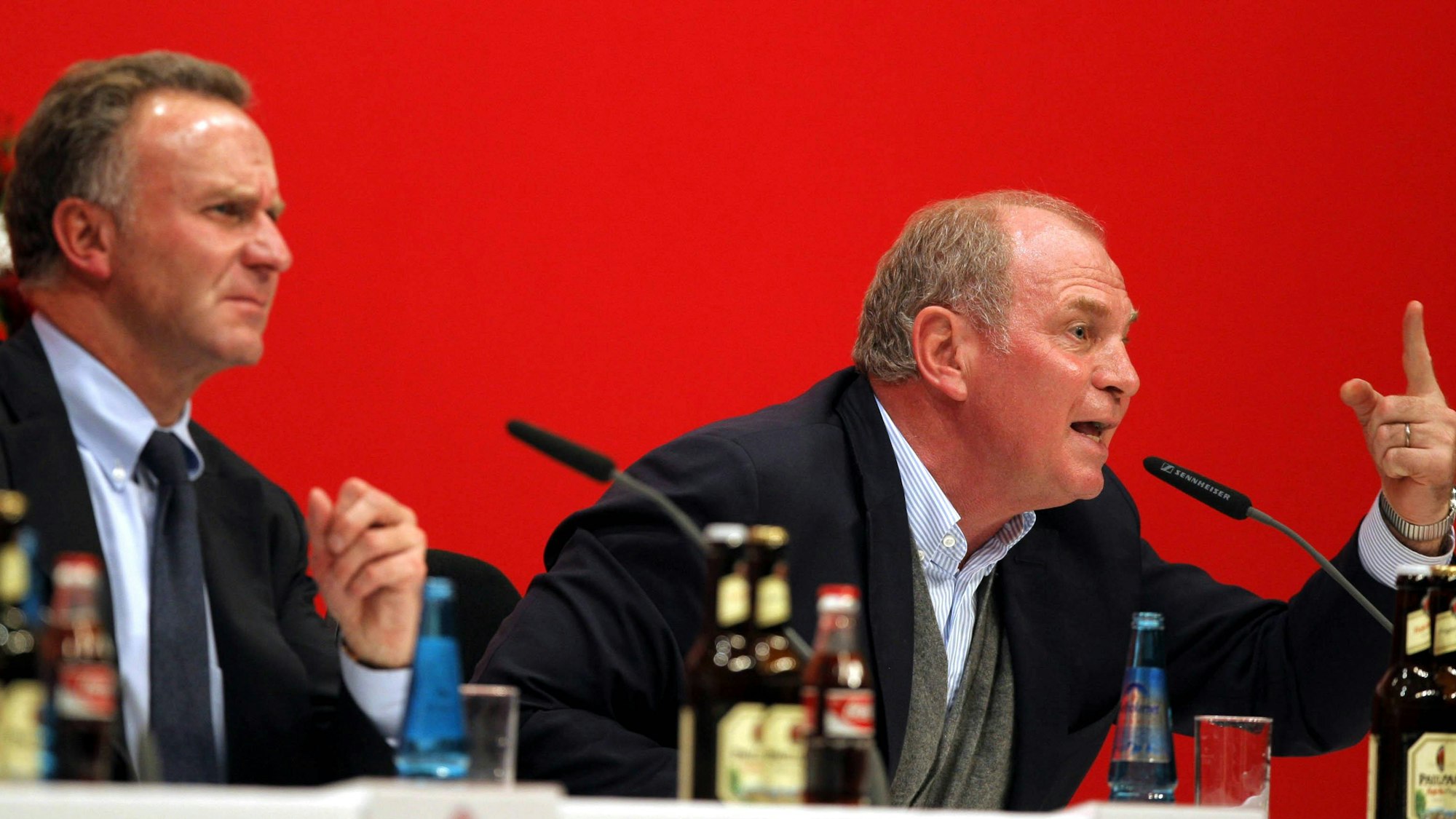 Rummenigge sitzt links neben dem wütenden Hoeneß auf der Bühne bei der Jahreshauptversammlung im Jahr 2007.