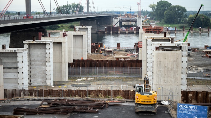Autos fahren am 145. September 2021 an der Baustelle für die neue Rheinbrücke vorbei. Am Neubau der Leverkusener Rheinbrücke werden mit mehreren Schwertransporten die ersten Stahlbauteile angeliefert. Insgesamt handele es sich um mehr als 1000 Tonnen Stahl, die die Brücke erreichten, teilte die Autobahn GmbH des Bundes mit.&nbsp;