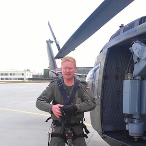 Der Kölner Soldat Boris Gießing steht neben einem Hubschrauber der Bundeswehr.