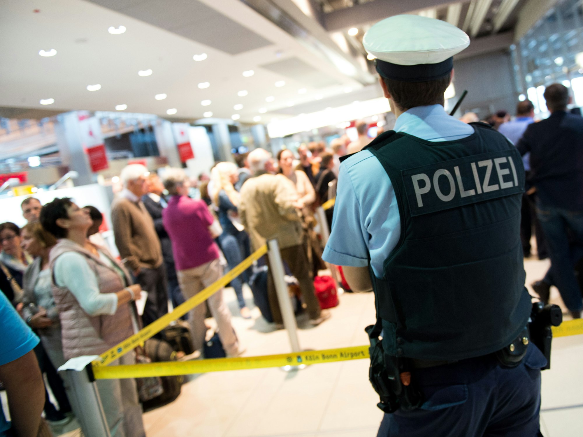 Ein Polizist steht vor dem Sicherheitsbereich im Flughafen Köln/Bonn.