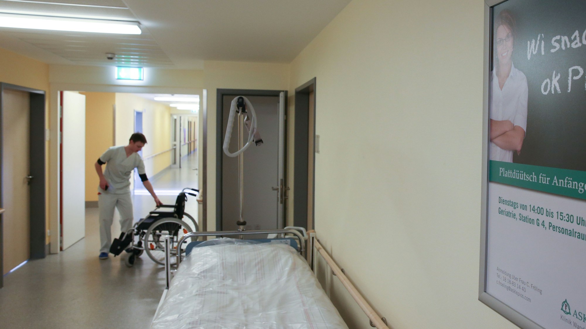 Ein Mann steht 2013 in einem Hamburger Krankenhaus an einem Rollstuhl.