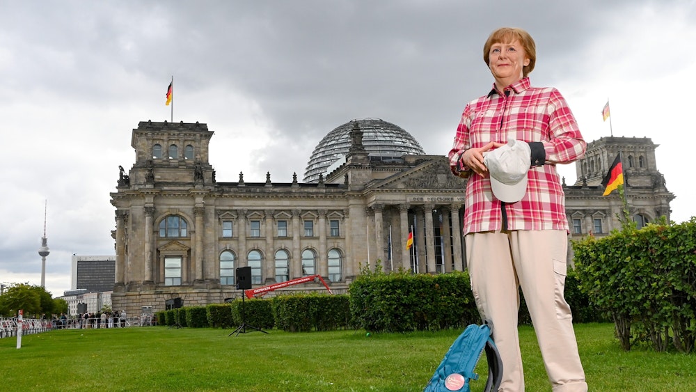 Die Wachsfigur von Bundeskanzlerin Angela Merkel (CDU) aus Madame Tussauds Berlin steht im Freizeitlook mit Rucksack, Basecap vor dem Reichstagsgebäude.