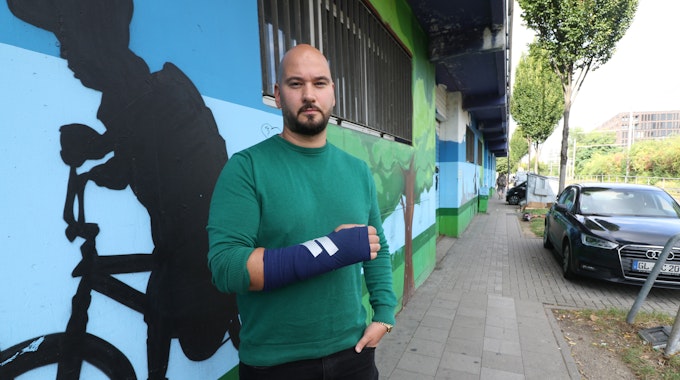 Der Kölner Murat K. (40) zeigt seinen Arm, an den ein Gips angebracht wurde.