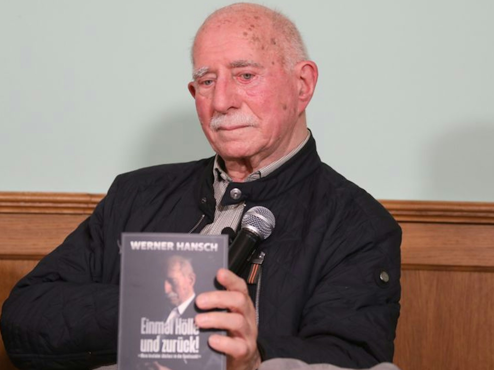 Werner Hansch zeigt sein Buch Einmal Hölle und zurück.