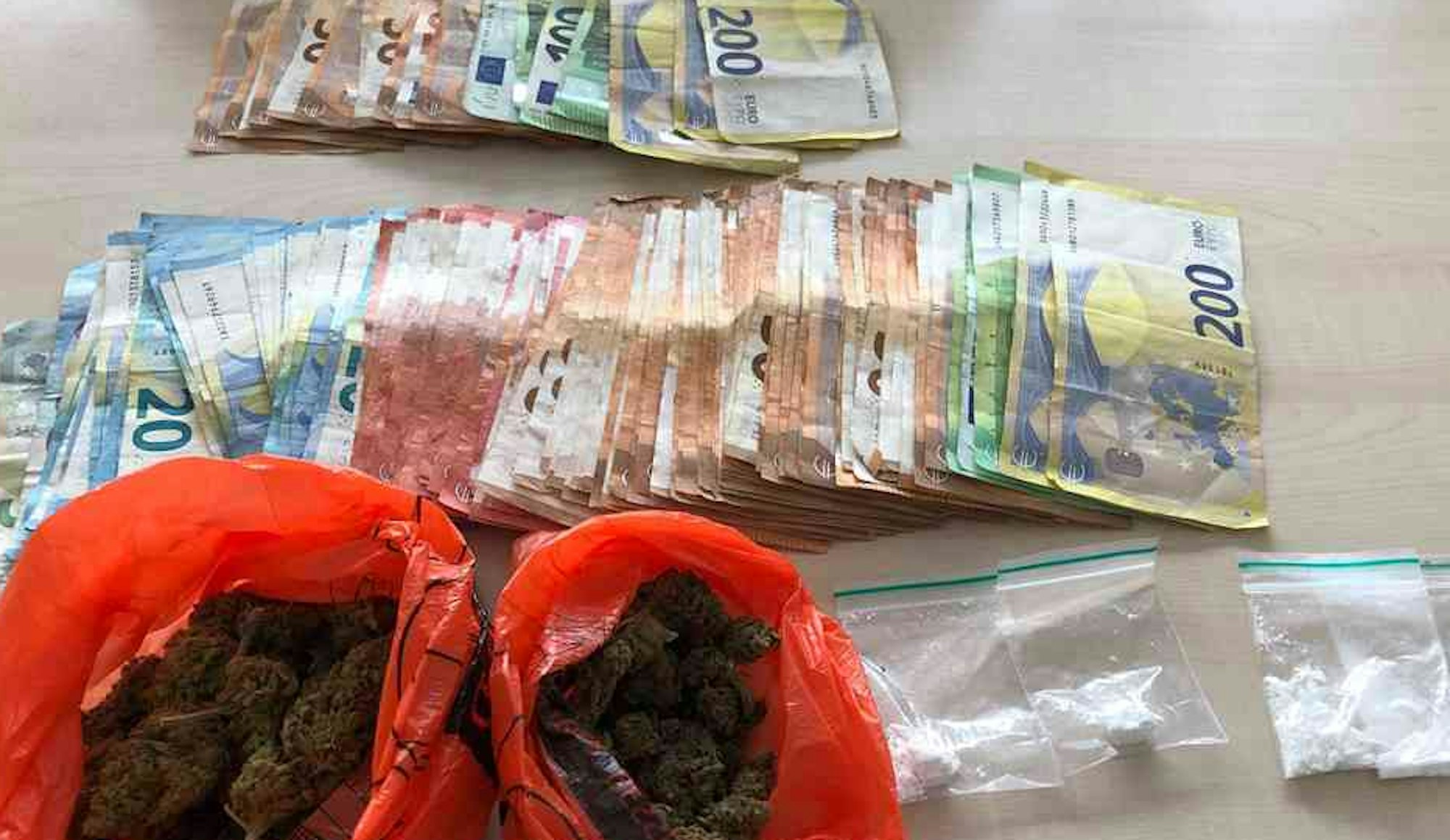 Drogengeld, Marihuana und Kokain liegen auf einem Tisch