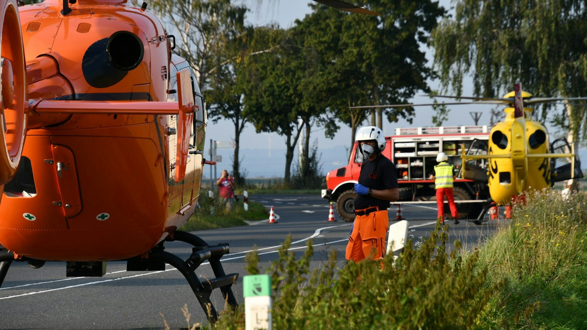 Einsatzkräfte neben zwei Rettungshubschraubern nach dem Unfall in Erftstadt am Samstag (18. September).