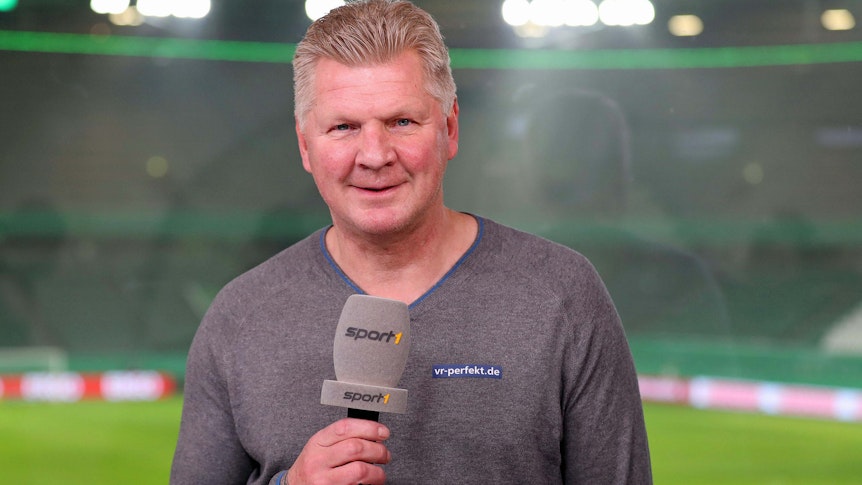 Ex-Gladbach-Spieler Stefan Effenberg arbeitet als TV-Experte für den Sender „Sport1“. Auf diesem Foto ist der ehemalige Nationalspieler am 3. Februar 2021 zu sehen. Effenberg hält das Mikro in der Hand und lächelt in die Kamera.
