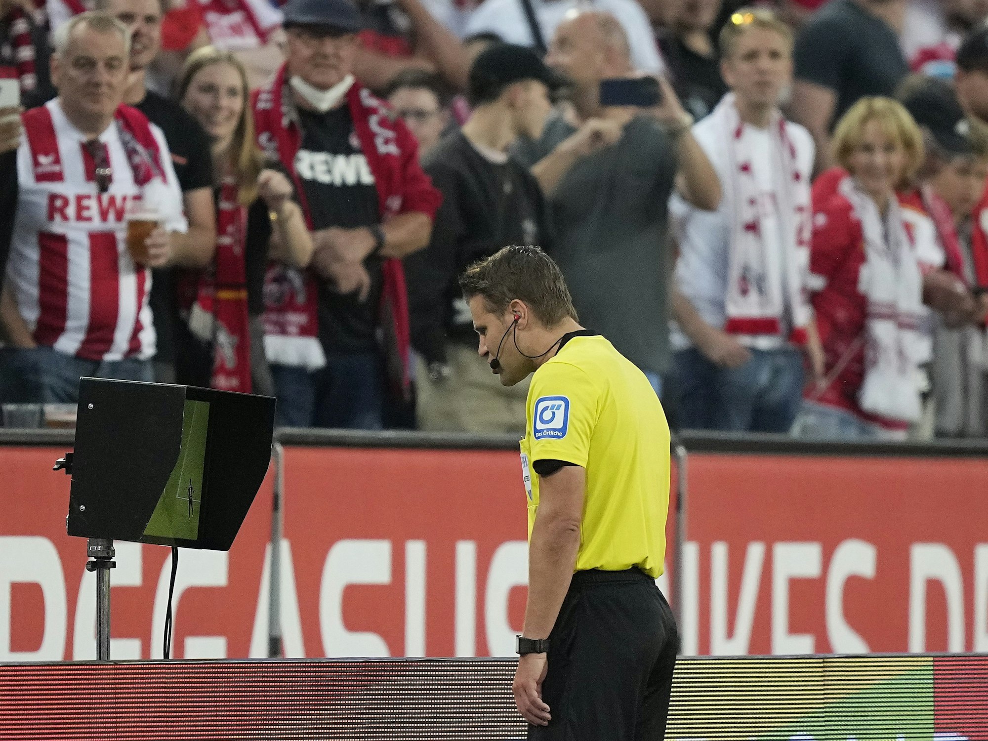 Felix Brych schaut sich bei 1. FC Köln gegen RB Leipzig eine strittige Szene am TV-Bildschirm an.
