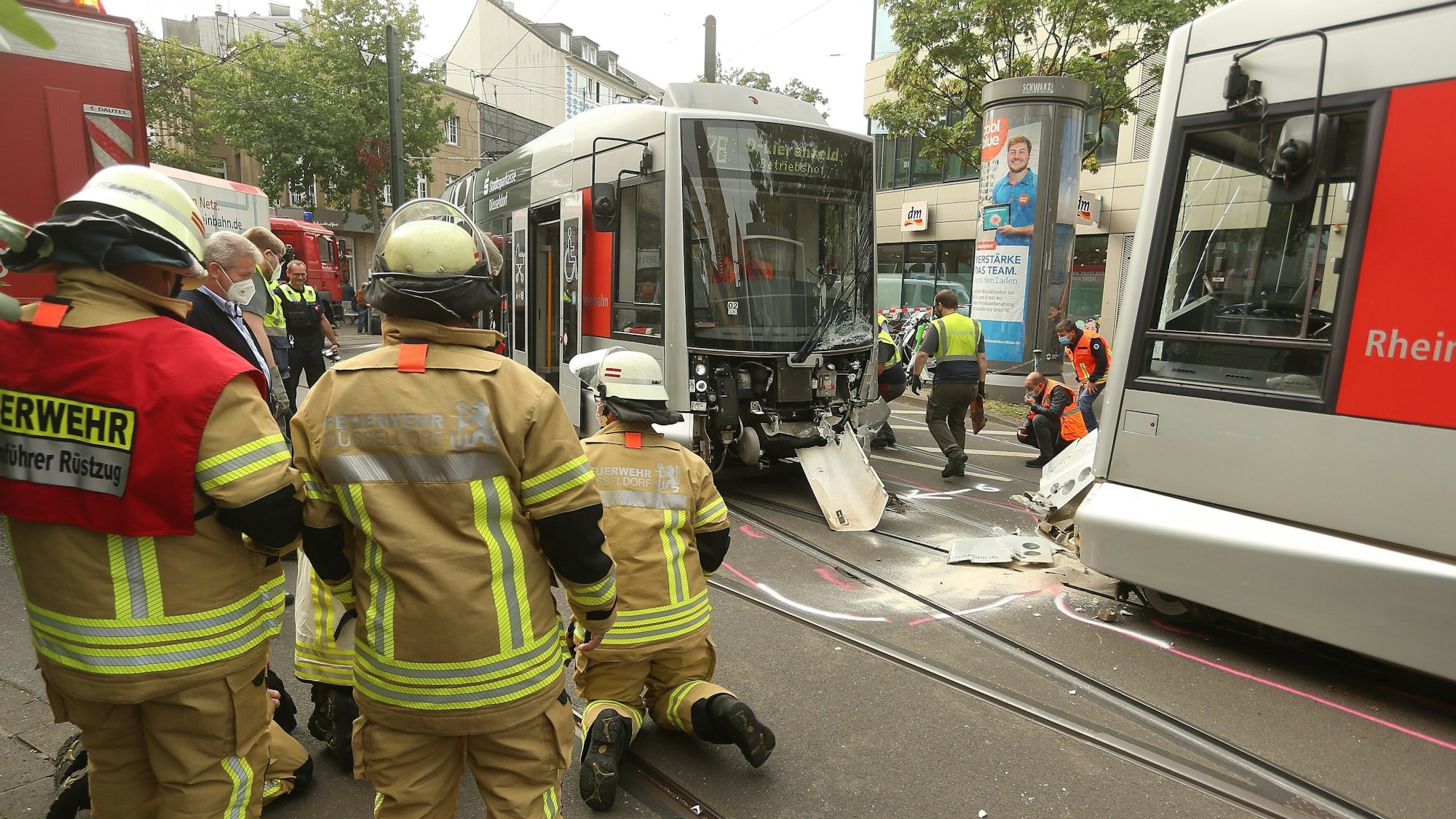 Mitglieder der Feuerwehr sind vor Ort, nachdem zwei Straßenbahnen der Düsseldorfer Rheinbahn am Montag, 20. September 2021, zusammengestoßen sind.