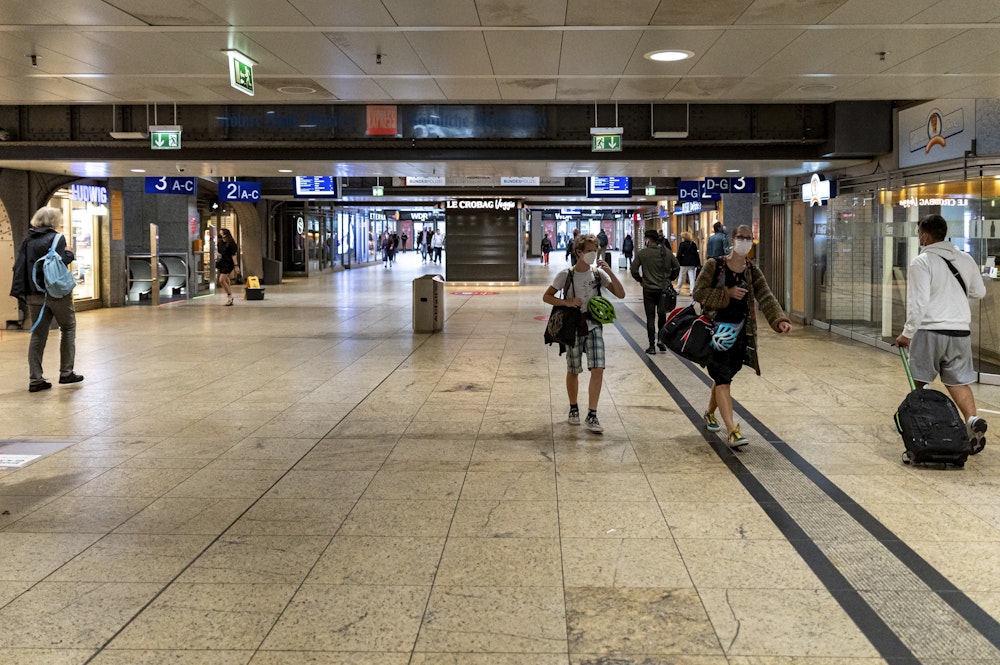 Menschen mit Gepäck gehen durch den Kölner Hauptbahnhof. Foto von Alex Roll, honorarfrei