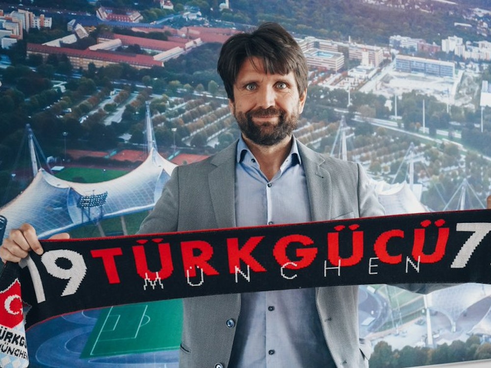 Trainer Peter Hyballa hält einen Schal seines neuen Vereins Türkgücü München hoch.