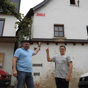 Familie in Dernau zeigt Pegelstand des Hochwassers von Juli 2021