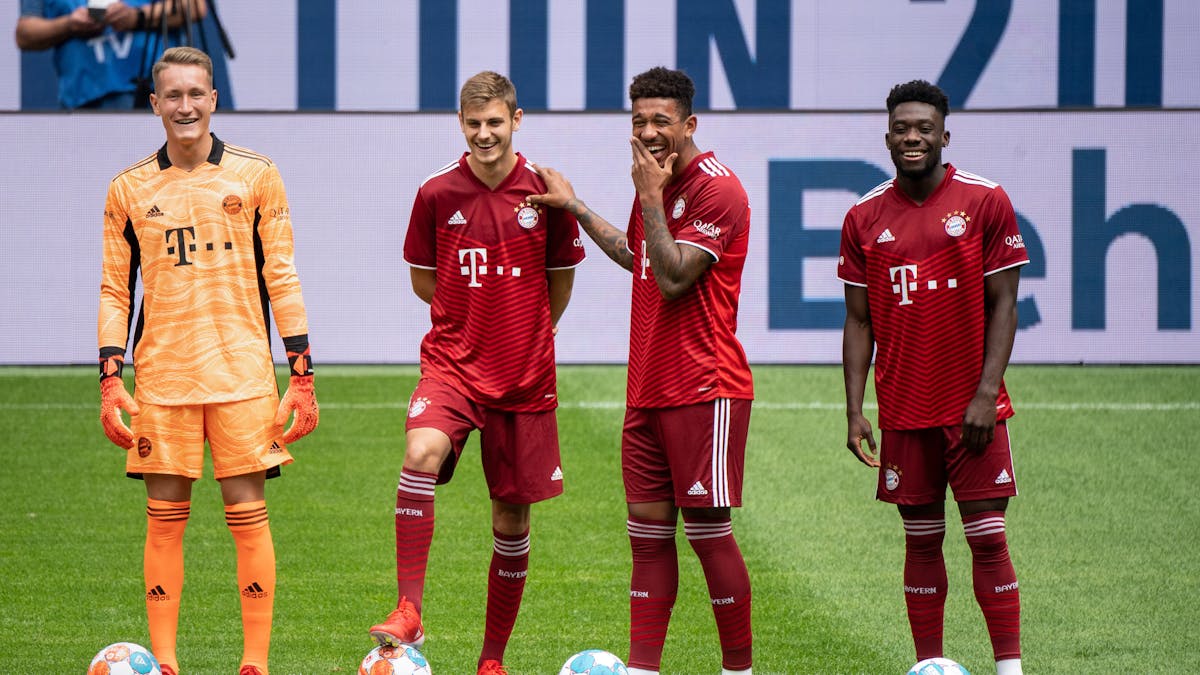 Ron-Thorben Hoffmann und die Spieler Josip Stanisic, Chris Richards und Alphonso Davies lachen auf dem Platz in der Allianz Arena