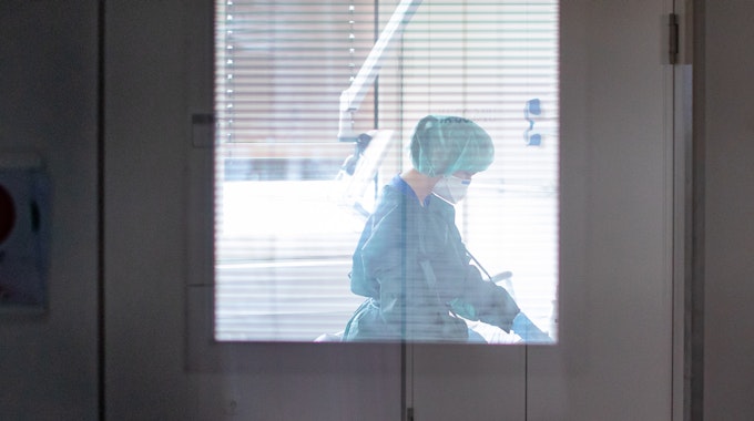 Eine Krankenschwester auf der Infektionsstation der Uniklinik Essen versorgt am 28. Februar 2020 in Schutzkleidung und mit einer Atemmaske einen Patienten. (