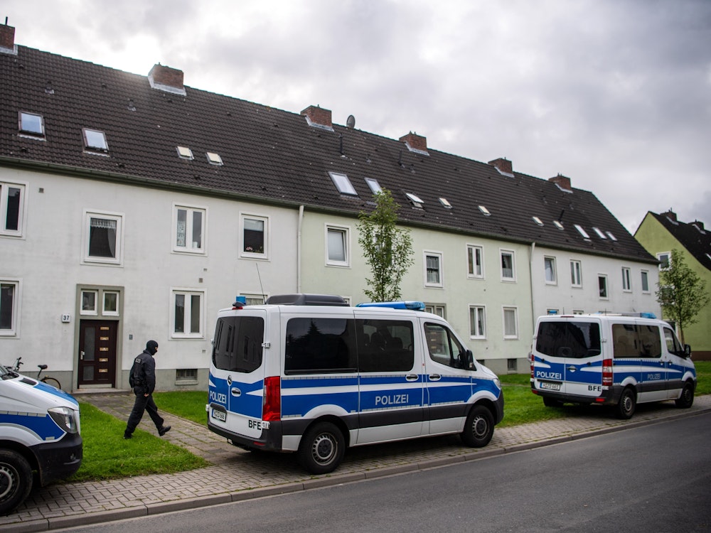 Polizei-Autos vor einem Mehrfamilienhaus.
