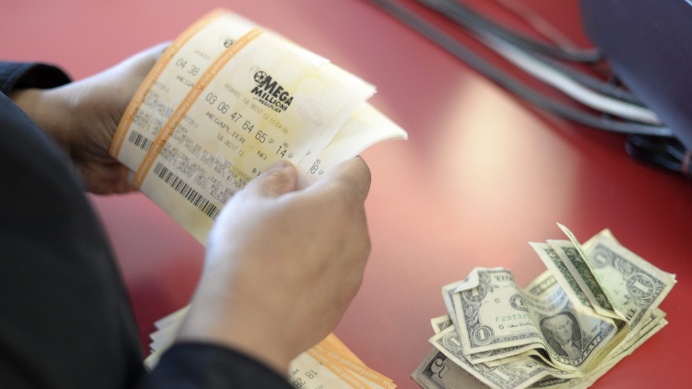 Unser Symbolfoto zeigt einen Kunden, der Scheine der Lotterie „Mega Millions“ im Dezember 2013 erwirbt.