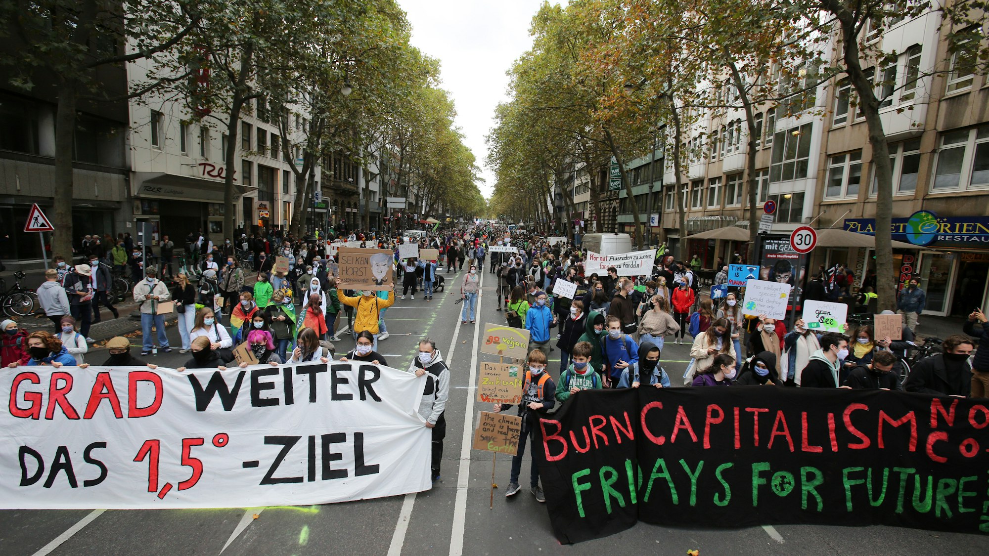 Demonstrierende Menschen laufen über die Kölner Ringe.