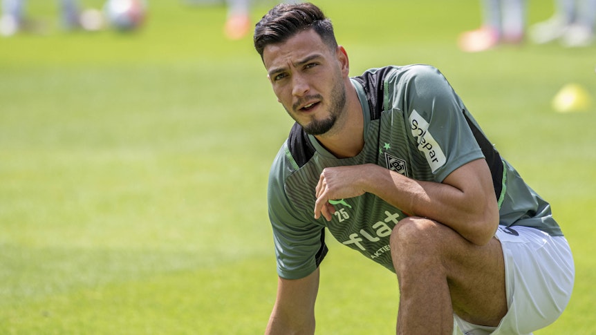Ramy Bensebaini von Borussia Mönchengladbachschaut am 17. Juli bei der Vorbereitung auf den Boden kniend nach oben.