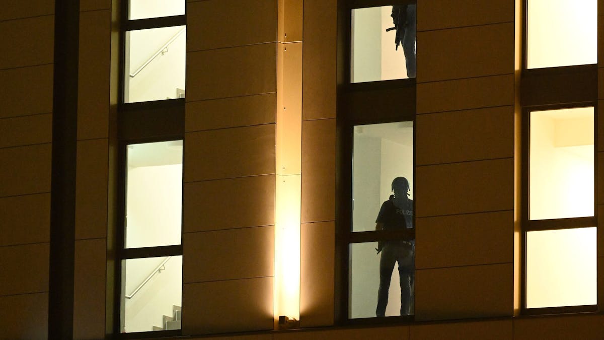 Spezialkräfte der Polizei sind im Einsatz in einem Düsseldorfer Hotel. Durch die Hotelfenster sind die Silhouetten der Beamten zu sehen, die das Gebäude durchsuchen.