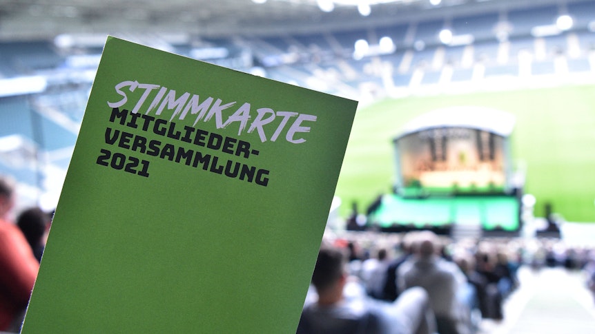 Ein Mitglied von Fußball-Bundesligist Borussia Mönchengladbach zeigt seine Stimmkarte bei der Mitgliederversammlung am 10. August 2021 im Borussia-Park. Auf der grünen Stimmkarte ist zu lesen: „Stimmkarte, Mitgliederversammlung 2021“.