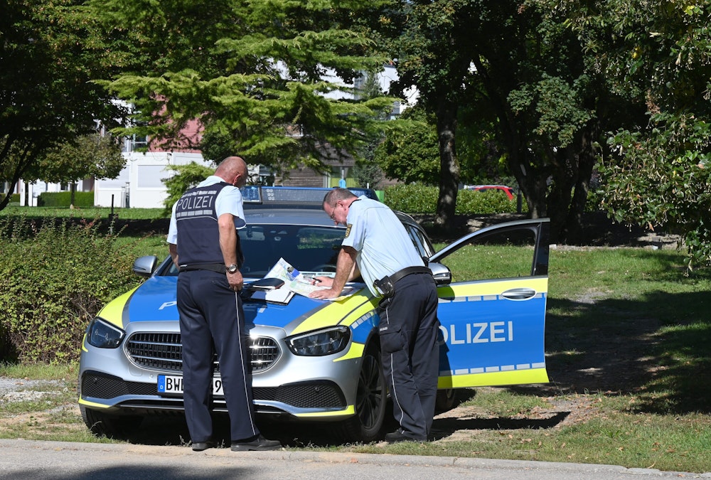 Polizisten besprechen sich vor der Klinik am Weissenhof in Weinsberg. Strafgefangene waren zuvor aus der Psychatrie ausgebrochen.