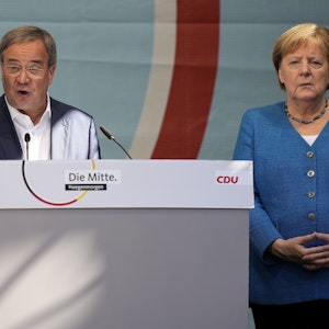 CDU-Kanzlerkandidat Armin Laschet und Noch-Kanzlerin Angela Merkel bei ihrem gemeinsamen Wahlkampfauftritt am Samstag, 25. September, in Aachen. Laschet spricht ins Mikro, Merkel steht daneben.