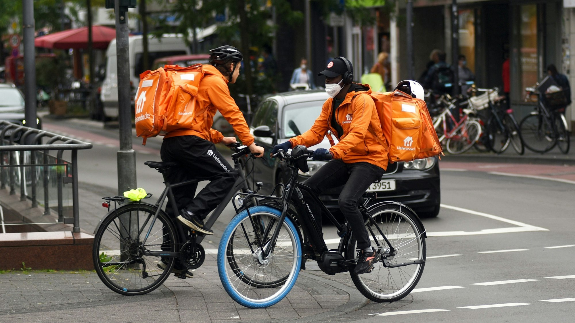 Zwei Lieferando-Fahrer fahren auf der Venloer Straße in Köln.