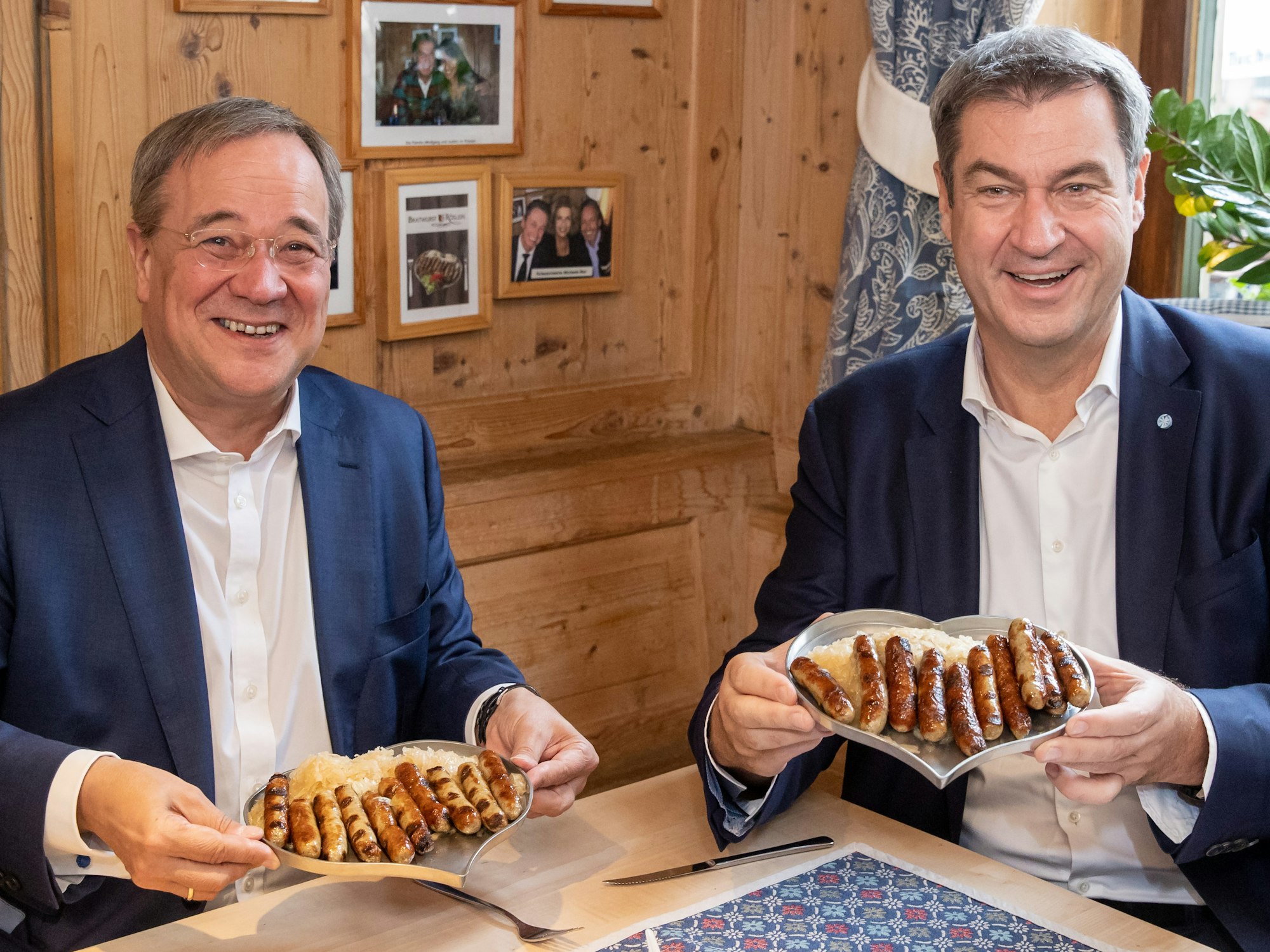 Markus Söder (r), CSU-Parteivorsitzender und Ministerpräsident von Bayern, und Armin Laschet, Unions-Kanzlerkandidaten, CDU-Vorsitzender und Ministerpräsident von Nordrhein-Westfalen, essen zusammen in einem Bratwurst-Restaurant Nürnberger Würstchen.