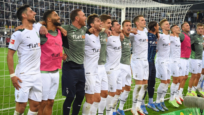 Die Mannschaft von Borussia Mönchengladbach feiert Arm in Arm lachend den Sieg gegen den BVB am 25. September 2021.