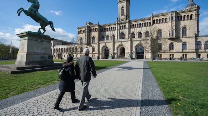 Zwei Passanten gehen auf einem Fußweg zur Leibniz Universität.&nbsp;