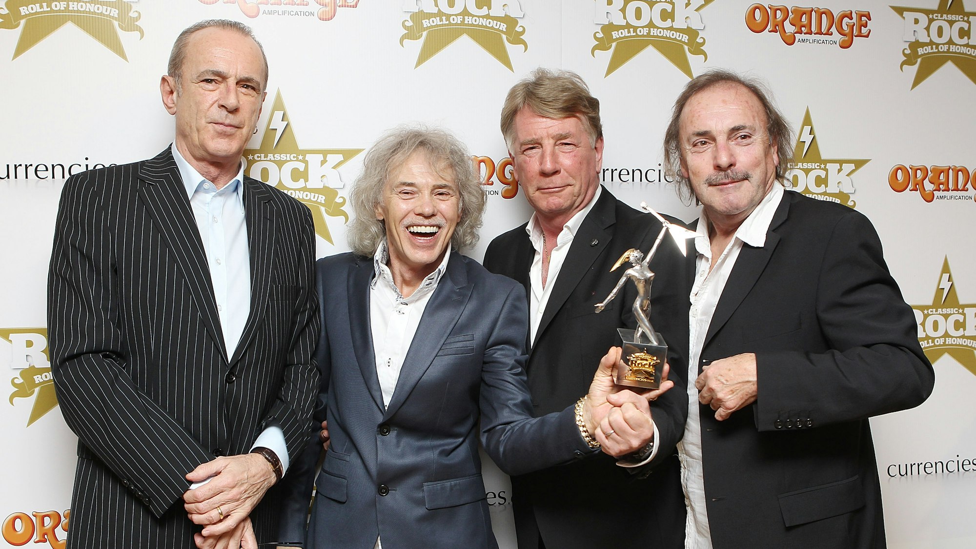 Francis Rossin (v.l.), Alan Lancaster, Rick Parfitt und John Coghlan der Band „Status Quo“ posieren mit dem „The Classic Album Award“ im Jahr 2012 in London.