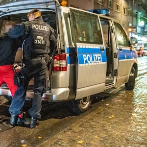 Die Polizei führt nachts auf der Zülpicher Straße eine Leibesvisitation durch.