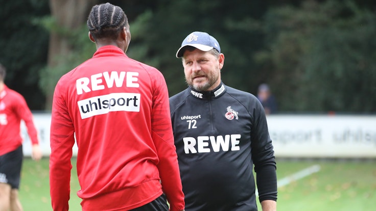 Steffen Baumgart spricht beim Training des 1. FC Köln mit Kingsley Ehizibue.