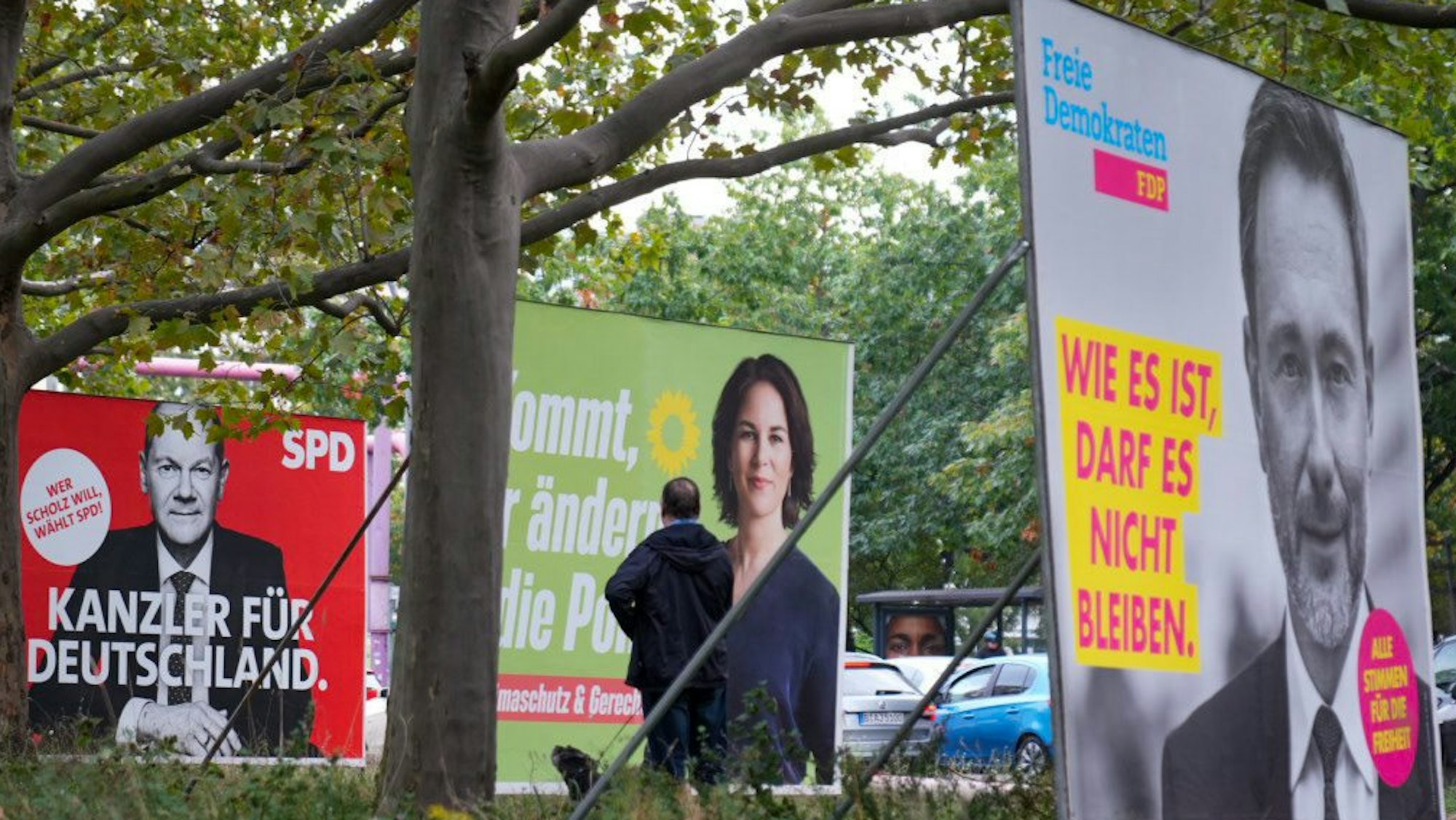 Wahlplakate der SPD mit Olaf Scholz, von Bündnis 90/Die Grünen mit Annalena Baerbock und der FDP mit Christian Lindner stehen auf einer Straße nebeneinander.