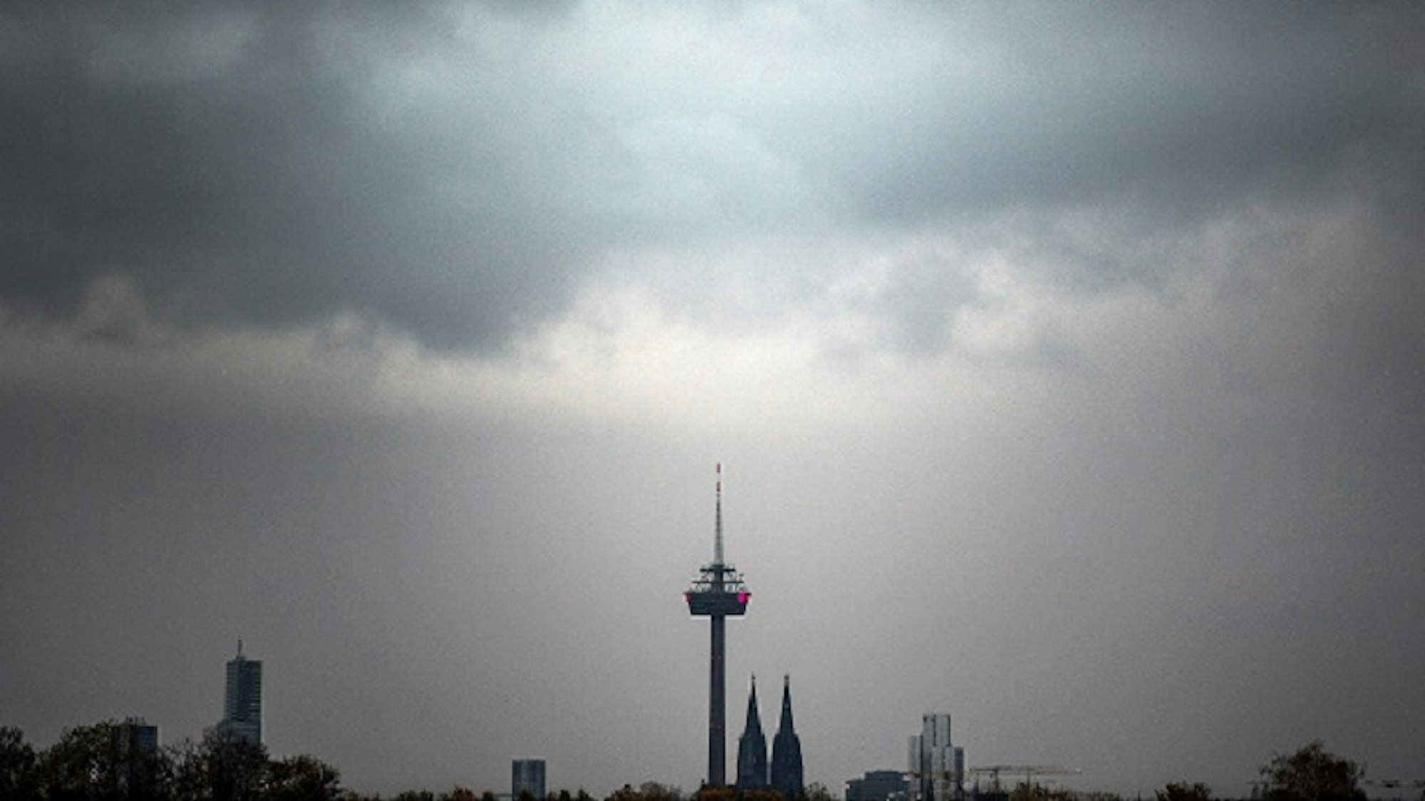 Wolken ziehen am Morgen über den Kölner Dom und den Fernsehturm.