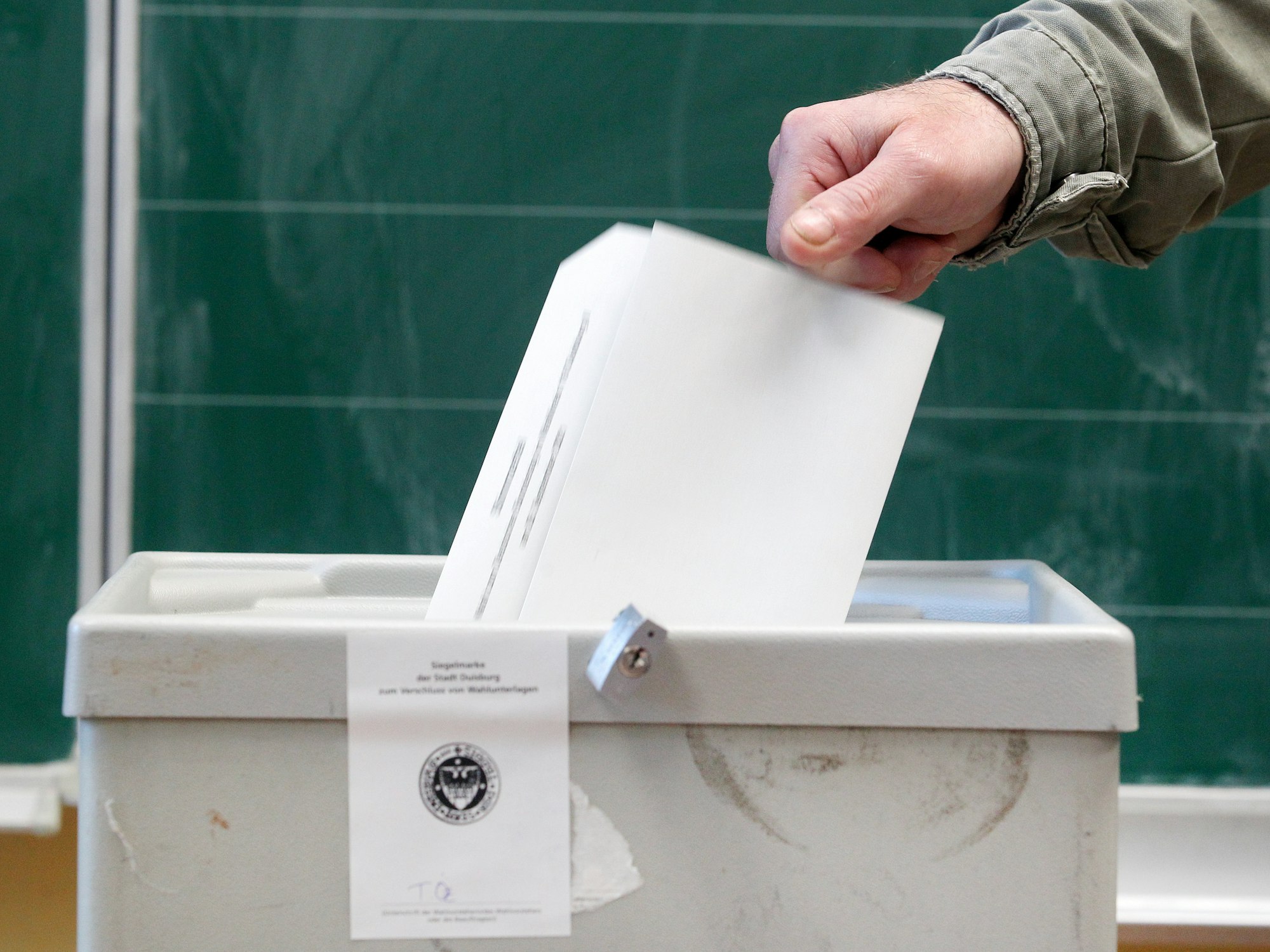 Ein Wähler wirft seinen Stimmzettel in einem Wahllokal in die Wahlurne.