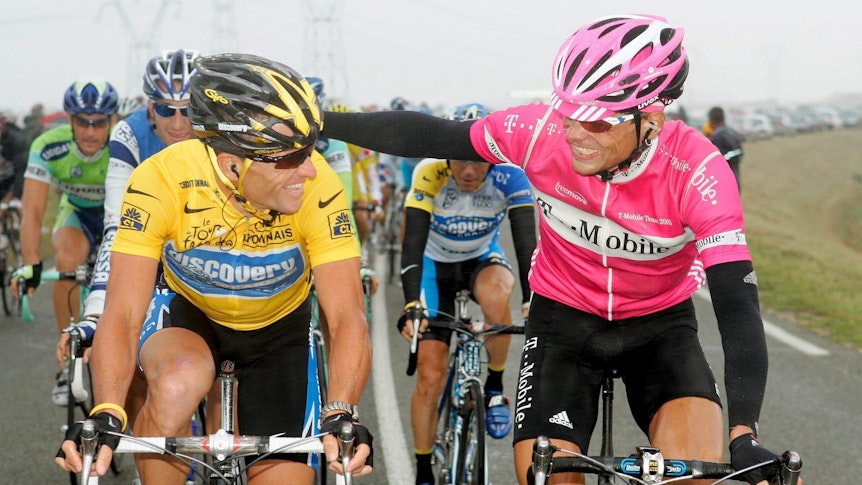 ARCHIV - Lance Armstrong (l) vom Team Discovery Channel unterhält sich am 24.07.2005 auf der Final-Etappe der Tour de France mit seinem jahrelangen deutschen Kontrahenten Jan Ullrich vom Team T-Mobile.