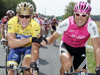 Der deutsche Radprofi Jan Ullrich reicht dem späteren Tour de France-Sieger Lance Armstrong aus den USA auf der Schlussetappe 2004 die Hand.