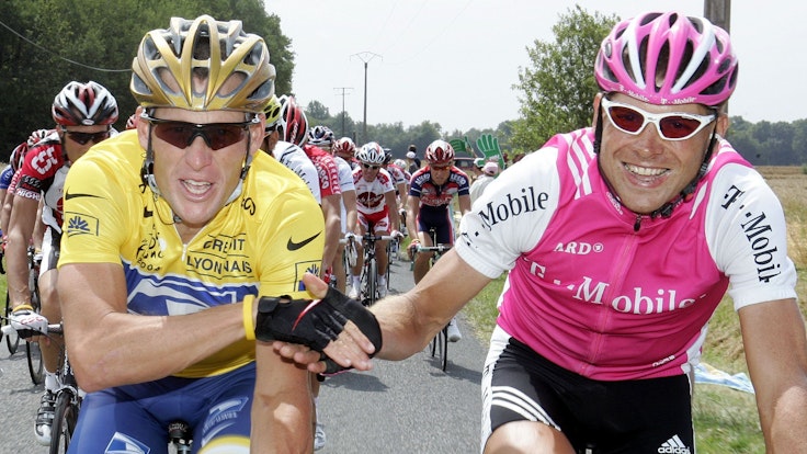 Der deutsche Radprofi Jan Ullrich reicht dem späteren Tour de France-Sieger Lance Armstrong aus den USA auf der Schlussetappe 2004 die Hand.