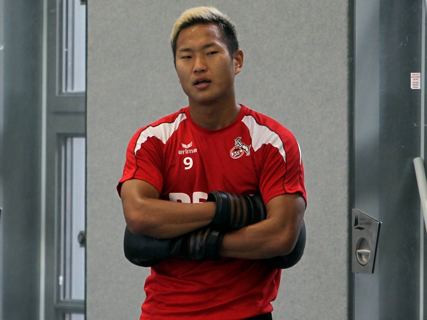 Chong Tese verschränkt die Arme, er trägt Boxhandschuhe.